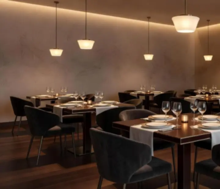 Sala privada com cadeiras estofadas, iluminação quente e detalhes de design contemporâneo.